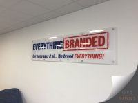 Clear perspex sign with logo and slogan for a company called "Everything Branded". Clear Perspex with a mixture of navy and red text.