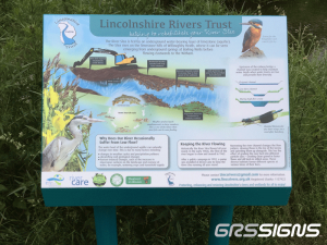 The illustrated display explains how the River Slea in Lincolnshire is fed by underground water from a limestone aquifer and shows a cross-section of the river, surrounding land, groundwater flows, river restoration features, and wildlife habitats. Images include a kingfisher in the top right, a heron in the lower left, fish and aquatic insects in the river, and diagrams comparing an original channel with a restored low-flow channel and flood channel. Text panels discuss why river flow can vary during periods of low flow and describe efforts to keep the river flowing. Logos of environmental organizations appear along the bottom, with contact details and the website www.lincsrivtrust.org.uk