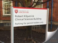 Dual-post external sign to show a building name and specify that only those with a permit may park here. (Installed at University of Leicester)