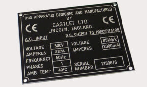 An engraved aluminium specification plate for an electrostatic precipitator manufactured by Castlet Ltd of Lincoln, England. The label details electrical input and output parameters, including voltage, amperes, frequency, and ambient temperature.