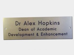 Engraved, paint-filled stainless steel name tag with drill holes for Dr Alex Hopkins