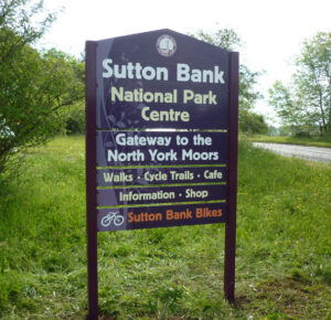 A modular sign installed outside, with bold text for Sutton Bank National Park Centre, and gateway to the North York Moors.