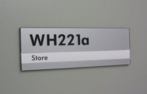 A close up of a tactile room number sign.