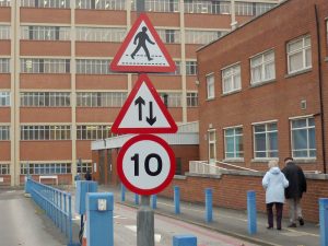 Lamppost traffic signs for pedestrians, give way and legal speed limit.