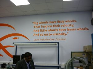 Bright orange wall art quote displayed on a large white wall.