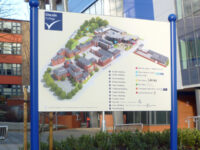 External dual-post mounted campus map at Lincoln College. A wayfinding sign for their campus, including a building diagram and key.