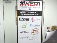 Large banner for #WOR1 (We Are One Racing), with reinforced eyelets for hanging/fixing - featuring a bold black, red, and white design. The banner displays the team's logo and slogan at the top, followed by the message "With Thanks to Our Sponsors". Sponsor logos including Fix Auto Collision, Grove Group, Oliver Brown, SSR Suspension, Alpha Photography, Sagegreen, and Bowlee Motorcycle Training are arranged in a clean grid layout across the banner. The contrasting colour scheme, strong typography, and professional sponsor presentation create an effective promotional display for motorsport events, exhibitions, and team sponsorship activities.